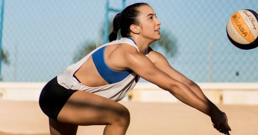 How to Hold Your Hands in Volleyball: Female beach volleyball player in action, focused and performing a dig during a game